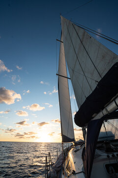 Sailing yacht heading towards a golden sunset on the atlantic ocean
