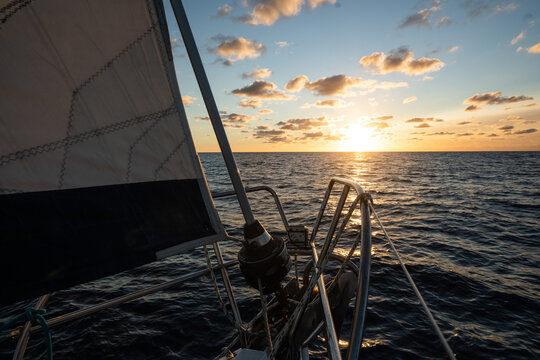 Sailing yacht heading towards a golden sunset on the atlantic ocean