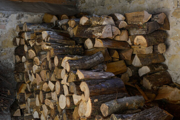 Pile de bois de chauffage coupé rangé dans un abri en pierres