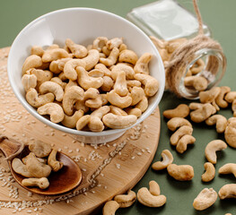 Peeled cashew nuts in a vine basket and scattered on a background