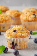 Lemon muffins with blueberries and shtreisel with fresh berries on a gray concrete background. Delicious breakfast. Copy space.