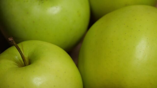 Four green apples, macro video. Apples of the Reinette Simirenko variety.
