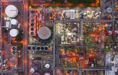 Vertical top down view above a chemical plant at night with pipelines & storage tanks laid out...