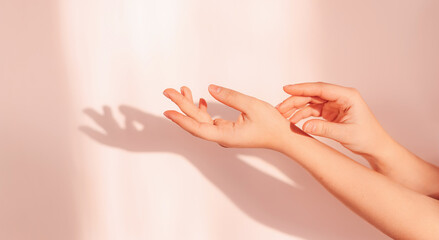 Gentle movements and gestures of female hands. gently touching her hands on a beige background. Elegant and graceful hands with delicate delicate fingers. a beautiful shade from the sun.