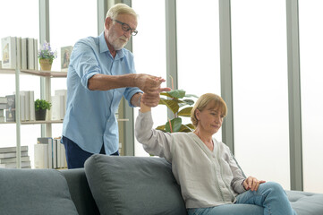 Senior caucasian man doing massage for his wife in living room
