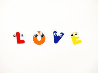 Obraz premium The word Love in Multicolored Letters with Eyes on a White Background.