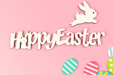 Happy easter spring holiday greeting card with colorful easter eggs on a bright pink background, top view photo, flat lay design
