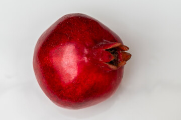 Whole pomegranate on white background. Space for text. Fresh raw fruit isolated on white background.