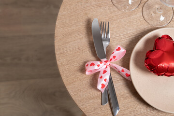 Cutlery and glasses with red heart-shaped balloon top view. Flat lay for romantic valentine's day  dinner