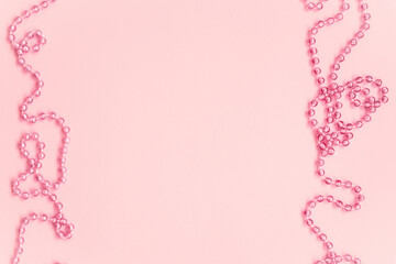 Valentines Day background. Rose beads on pastel pink background. Valentines day, wedding or girly birthday concept. Flat lay, top view, copy space