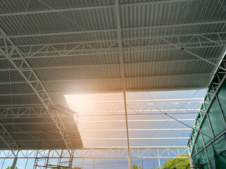 Look up view with flare. The space between cover steel structure thatch the roof of building in the construction.