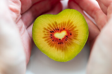 Red kiwi heart shaped with two hands