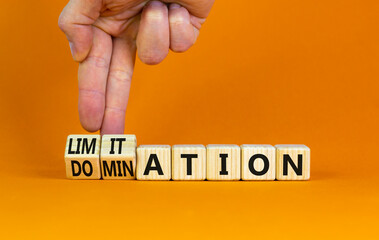 Domination or limitation symbol. Businessman turns cubes, changes the word domination to limitation. Beautiful orange table, orange background, copy space. Business, domination or limitation concept.