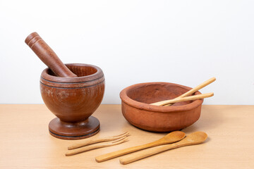 Set of various traditional kitchen utensils, made of wood and a clay bowl