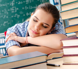 The female student with many books sitting in the classroom