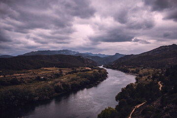 Curved river under a cloudy sky