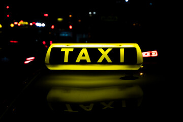 taxi in the city at night, glowing and reflexing taxi sign, bokeh,