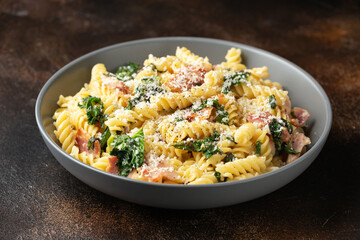 Fusilli pasta with bacon, kale and parmesan cheese. Healthy food - obrazy, fototapety, plakaty