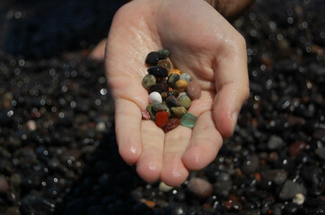 brightly colored river stones in hand