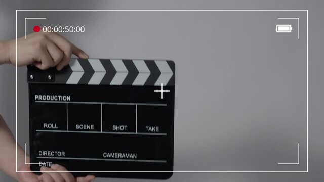 Movie slate or clapperboard hitting. Close up hand holding empty film slate and clapping it. Open and close film slate for video production. film production. color background studio. ready to shoot