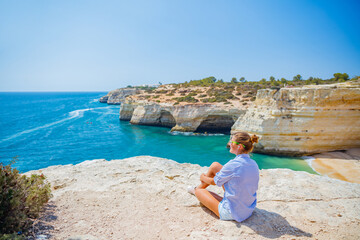 Girl looking out on the ocean. Lagos, Algarve Coast, Portugal - 480769105