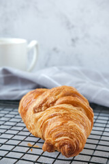 Croissants on baking rack with a cup of coffee
