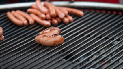 Grilled sausage on the flaming grill on dark background. Place for text.