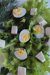 Salad with cheese, eggs and lettuce leaves, top view.