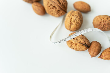 Beautiful whole walnut kernels, whole nuts in shell on a white table. Centimeter among nuts, low calorie nuts. Selective focus.