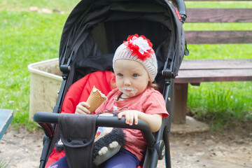 Baby girl eats ice cream in summer and gets her mouth dirty