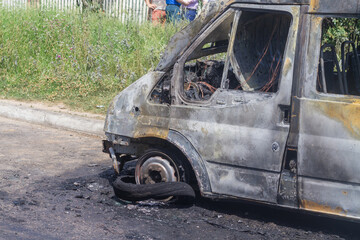 Obraz premium The car after the fire is covered with black soot on the city street