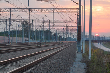 Fototapeta na wymiar Railroad Tracks and Overhead Power Supply at Sunset
