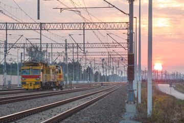 Fototapeta na wymiar Railroad Tracks, Maintenance Train and Overhead Lines at Sunset