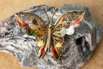 butterfly brooch on a sea sediment rock