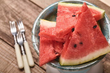 Slices of fresh watermelon in plate on wooden background. Mock up for design. Copy space.