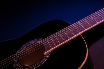 Obraz na płótnie Canvas black guitar side view close-up. guitar music low-key concept