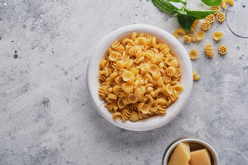 Pasta. italian pasta. Insalata di pasta and vegetables cooking ingredients, cheese and basil on old stone background. Italian food cooking ingredients. Top view with copy space.