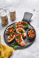 Chanterelle sandwiches with cheese. Open faced sandwich with creamy cheese, seasonings and pepper and fresh parsley on an old wooden background. Mock up. Top view.