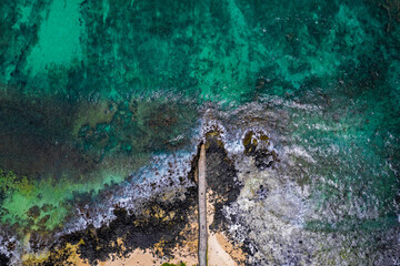 Aerial view of a fishing pier and the waves crashing on the south coast of Mauritius island