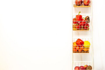 Vertical white rack with shelves full of vegetables and fruits, Slogan space