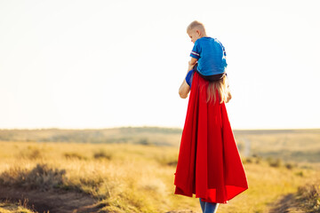 Mom and son play superheroes, Happy mom holds a small child in her arms, simulate flight, pretend...
