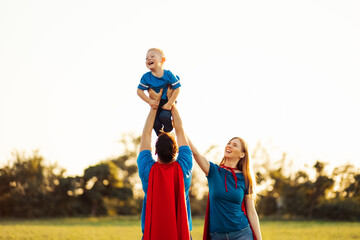 concept of european superfamily, outdoors, loving father holds on the neck, superhero family run at sunset in nature