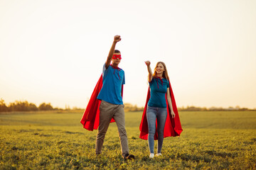 man and woman in superhero costumes, strong successful superheroes flying to the rescue, man and...