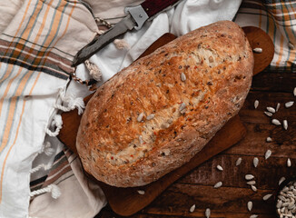 Freshly baked bread on a wooden board with a golden crust. Top view.