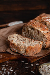 Sliced rye bread with a golden crust and sunflower seeds on cutting board. Healthy eating concept.