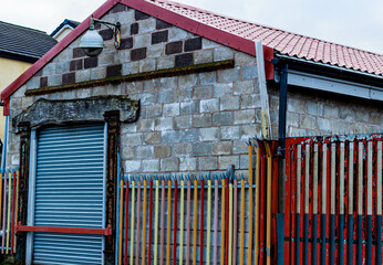 old small warehouse with a colored fence