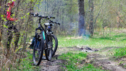 Fototapeta na wymiar two bicycles. A mountain bike stands on a trail in a spring forest. cycling outdoor. concepts of renovation, sports, cycling, activities. girl cyclist on active vacation. Ukraine, May 2021