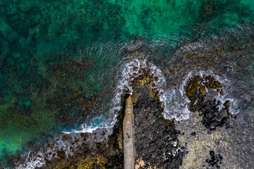 Aerial view of a fishing pier and the waves crashing on the south coast of Mauritius island