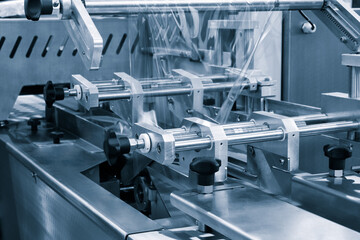 The operation of automatic plastic bag production machine with lighting effect. Close-up of the...