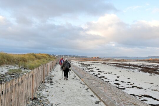 Senior hikers walking along the coast in Brittany-France - Powered by Adobe